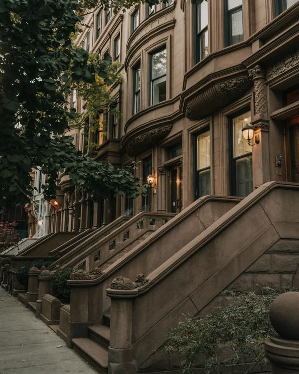 Brownstone stoops and bay windows on a Harlem block