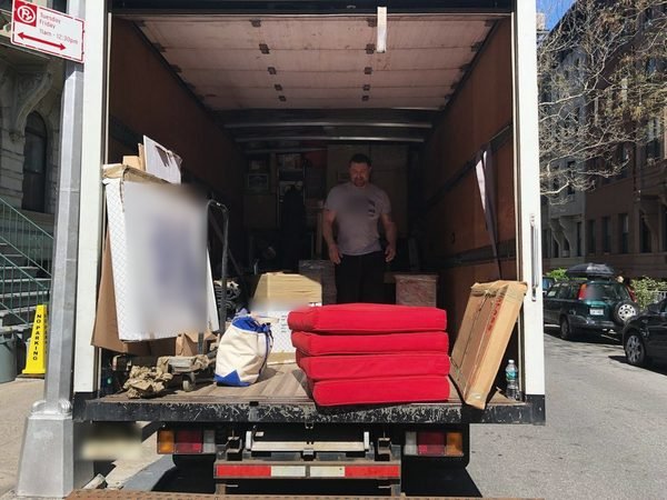 Our truck open at the curb on a city block, loaded with padded furniture and boxes