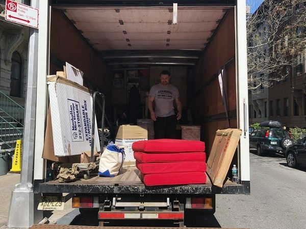 Our truck open at the curb on a city block, loaded with padded furniture and boxes