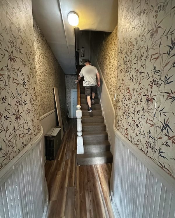 One of our movers carrying a load up a narrow walk-up staircase